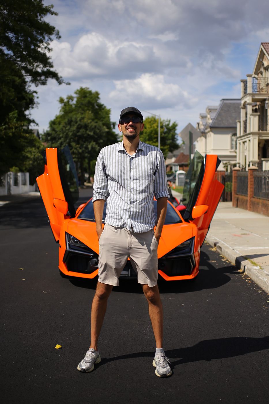 Vadim Divakov beside an orange supercar with its doors raised