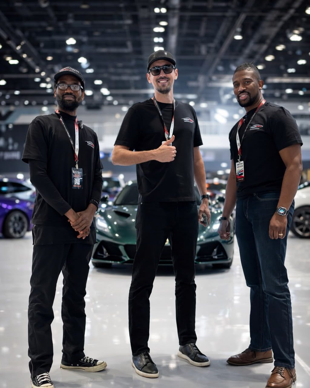 Vadim Divakov with the HOTCM team beside a supercar at an auto show